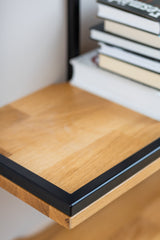 Close up view of solid wood floating shelf PÄIKE highlighting the black metal frame and solid wood grain