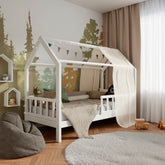 White wooden housebed ÖÖBIK with barriers in a modern and bright kids room decorated with pillows and toys