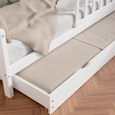 Close up view of the white solid wood toddler bed VARBLANE with drawers highlighting the pull-out bed