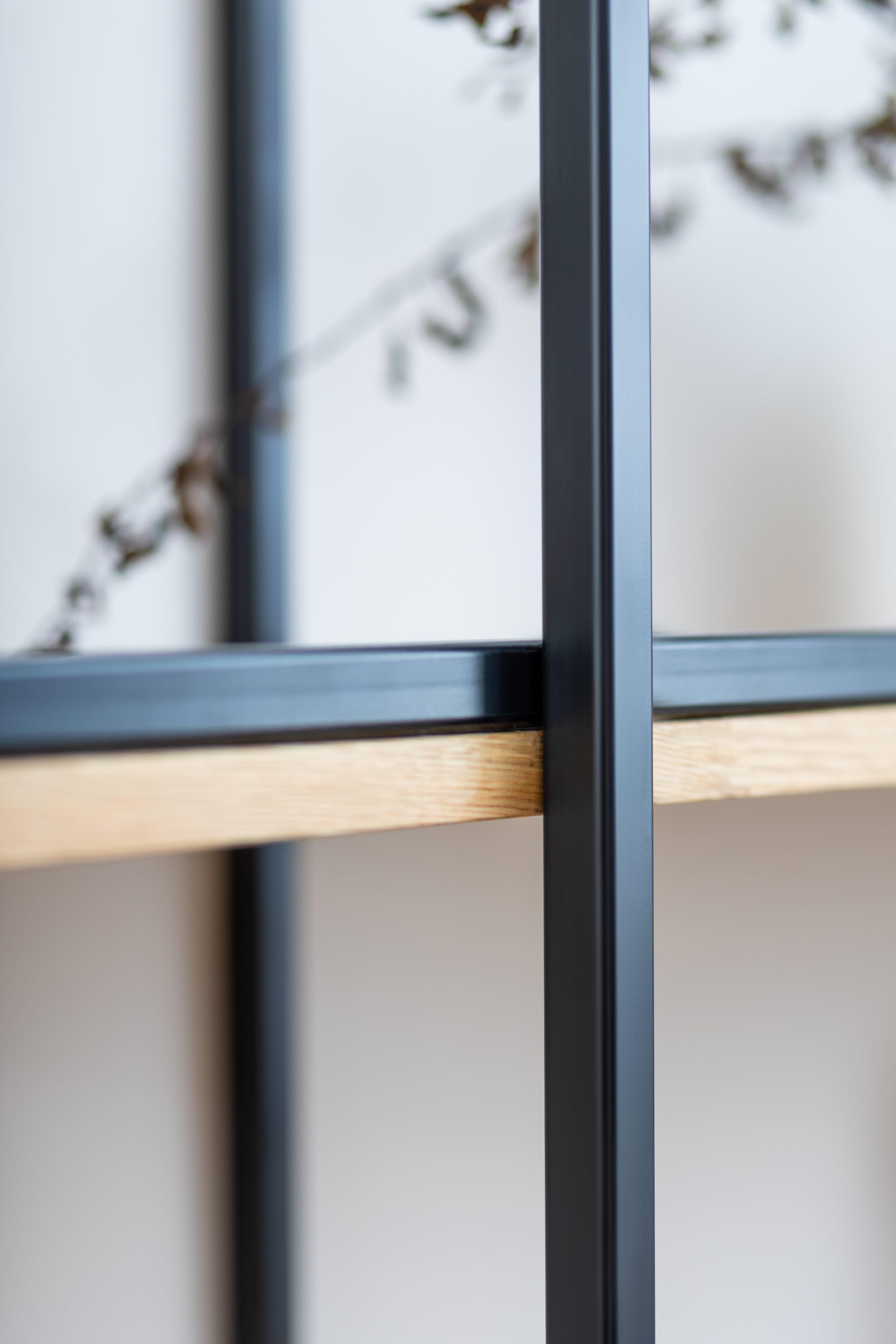 Close up view of solid wood floating shelf PÄIKE highlighting the sturdy black metal frame